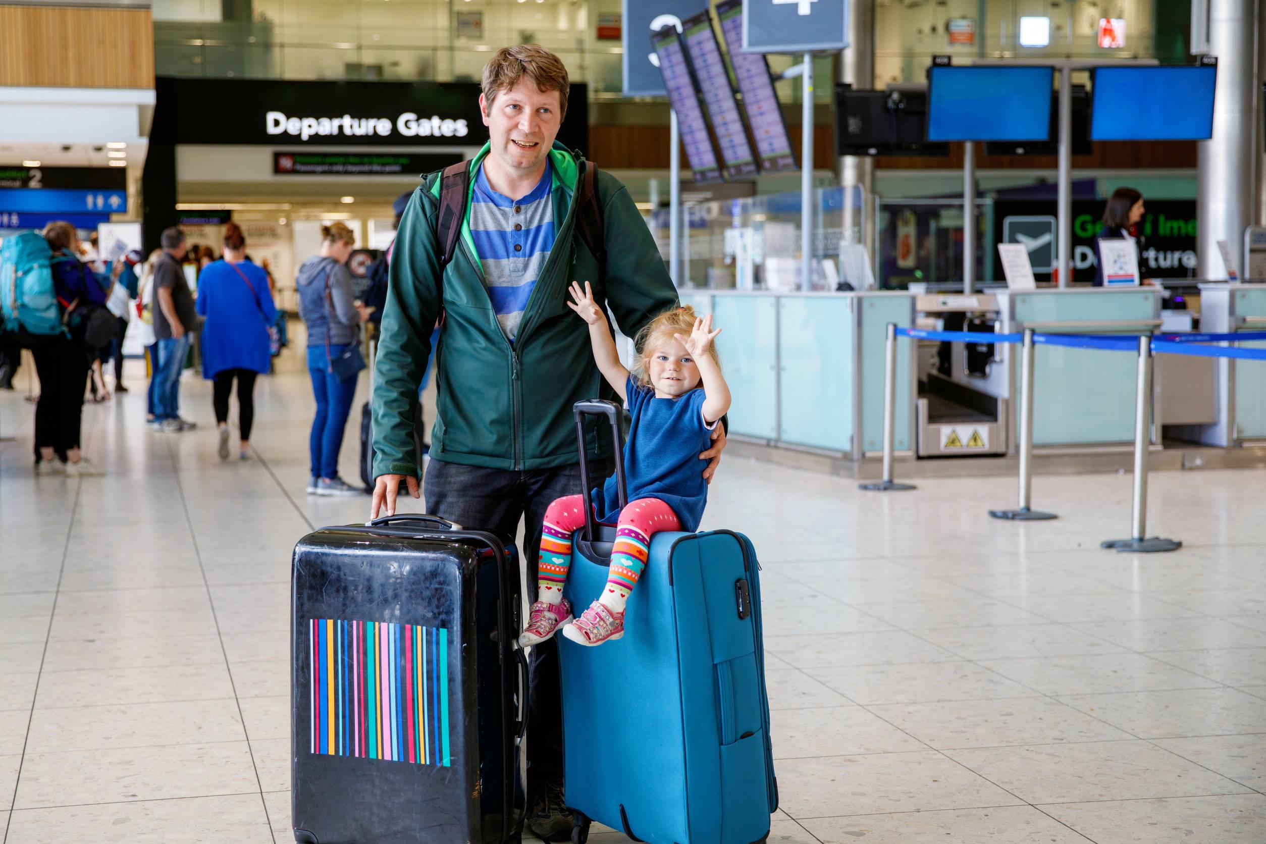 空港でかわいい幼児の女の子と父親が飛行機で旅行する幸せな家族
