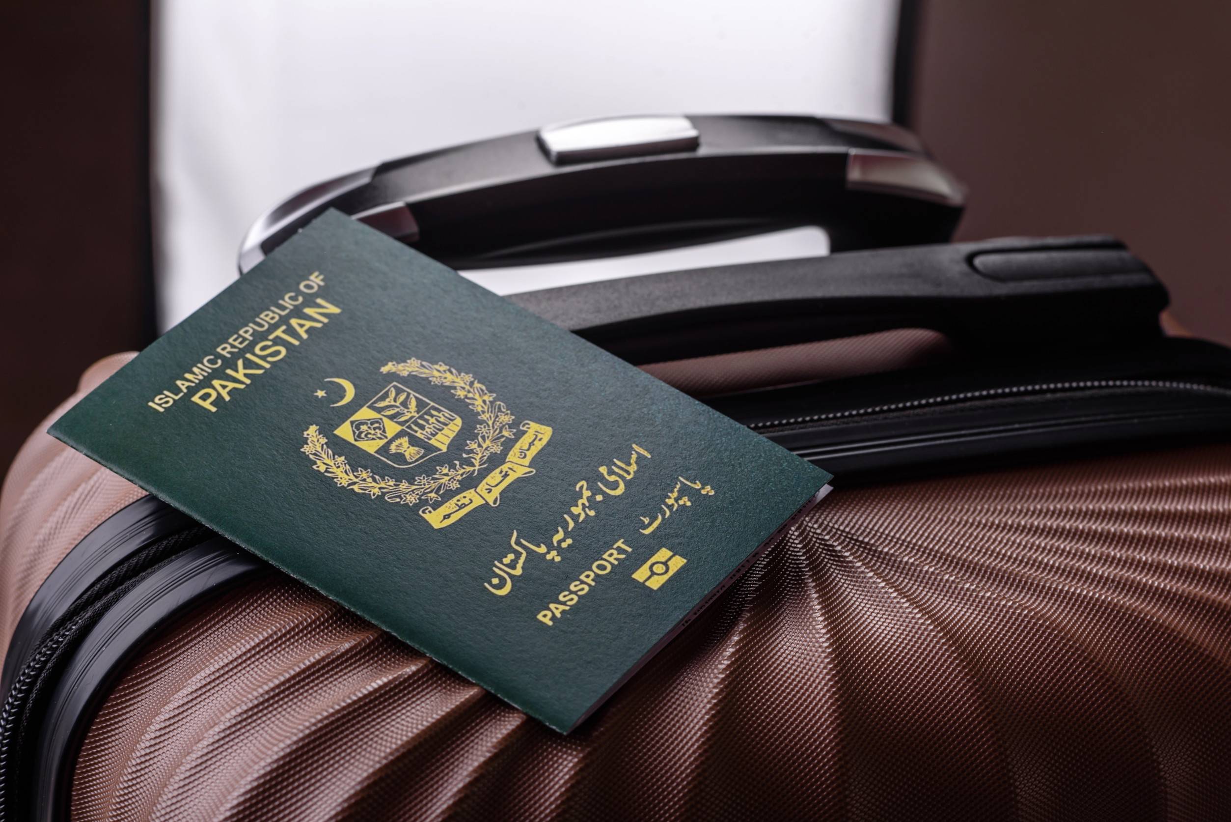 passaporto internazionale di un cittadino pakistano su una valigia - partenza dall'aeroporto